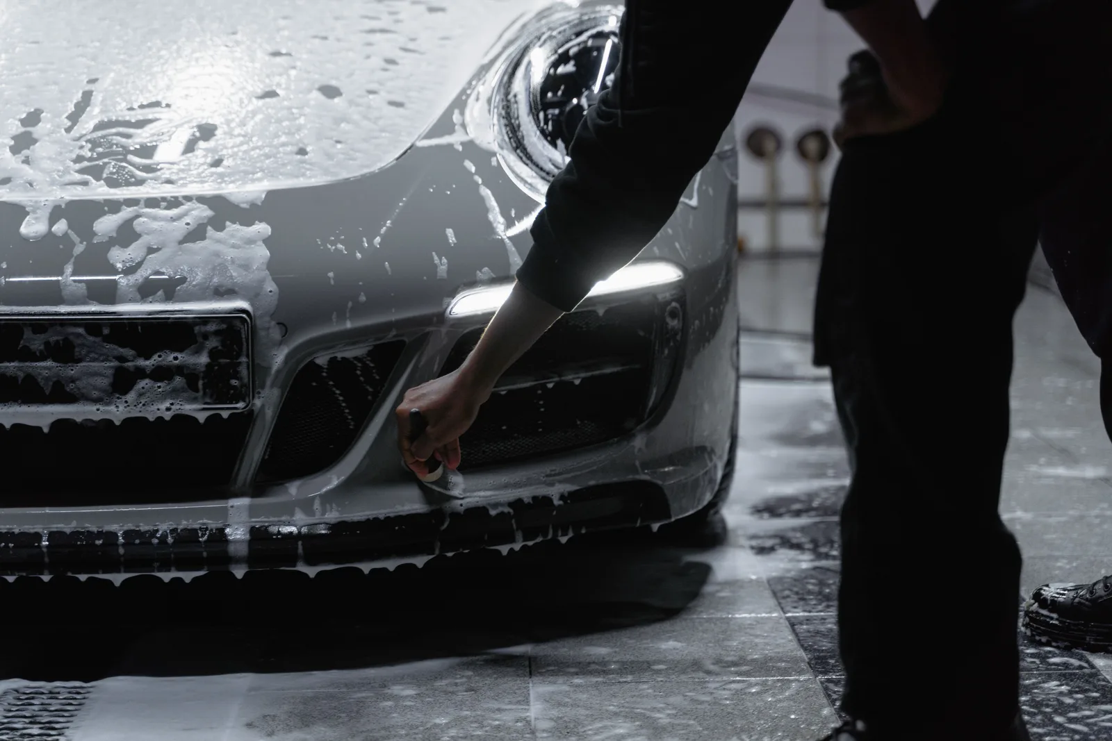 Close-up of a car being washed with soap